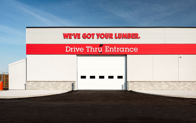 Exterior of home hardware with large bay dooe and the saying We've Got Your Lumber, Drive Through Entrance