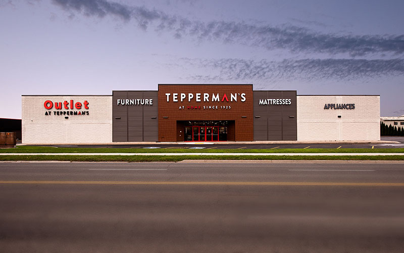 Teppermans Building, Commercial renovation construction project, view of the front of the building showing the front door which is surrounded by brown and white accents with their name written in white and red.